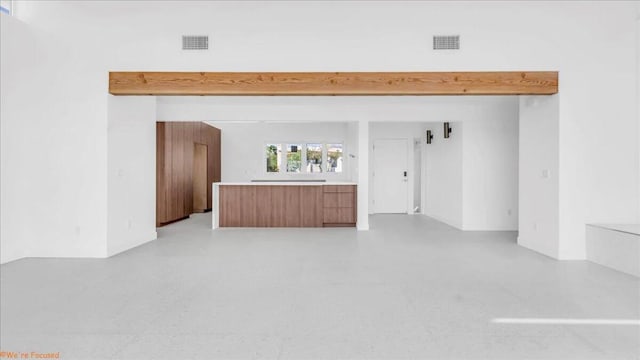 unfurnished living room with beamed ceiling