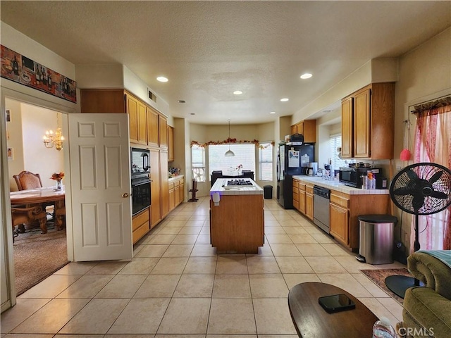 kitchen featuring a kitchen island, black appliances, and light tile patterned floors