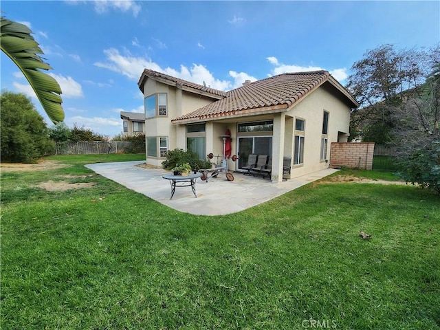 back of property with a patio area and a yard