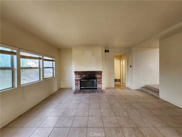 unfurnished living room with visible vents, a fireplace, light tile patterned flooring, and baseboards