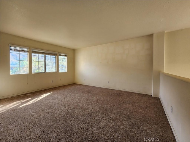 carpeted spare room with baseboards