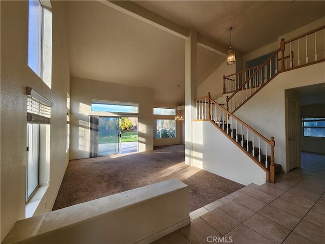 interior space featuring a towering ceiling, carpet, and tile patterned flooring