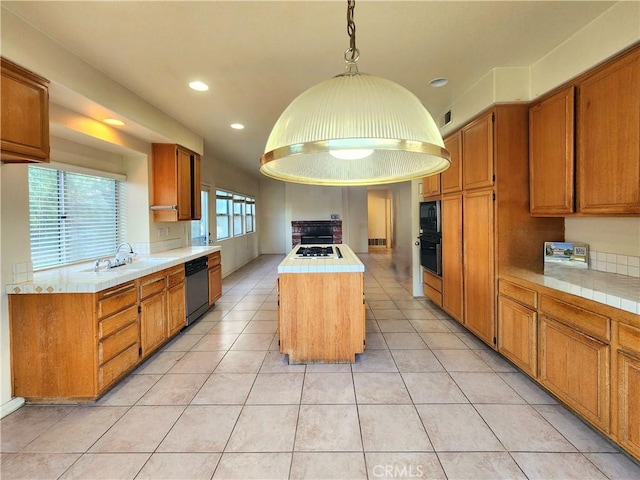 kitchen featuring decorative light fixtures, light countertops, a sink, a kitchen island, and black appliances