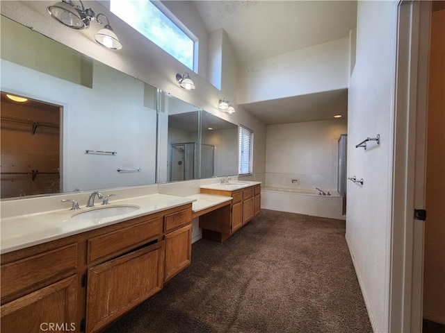 full bath featuring a stall shower, a garden tub, a high ceiling, carpet flooring, and vanity