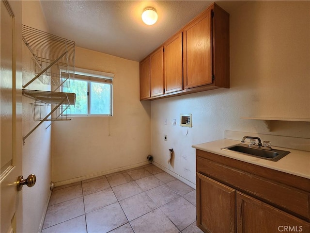 clothes washing area featuring hookup for a washing machine, a sink, baseboards, cabinet space, and electric dryer hookup