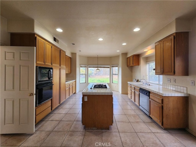 kitchen featuring hanging light fixtures, black appliances, a kitchen island, and brown cabinetry