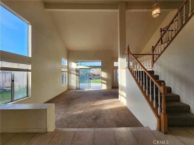 interior space with high vaulted ceiling, carpet flooring, and tile patterned floors