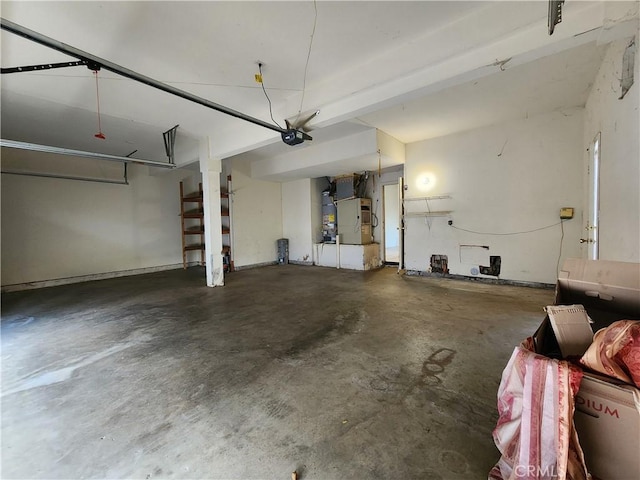 garage featuring heating unit, strapped water heater, and a garage door opener