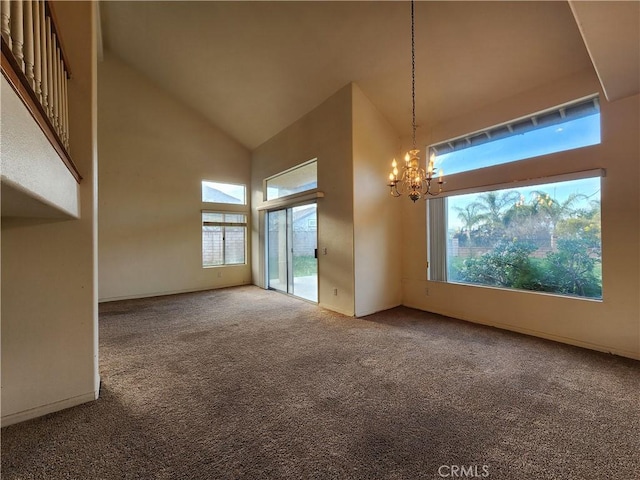 carpeted spare room with an inviting chandelier, baseboards, and high vaulted ceiling