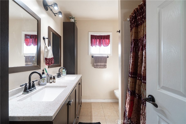 bathroom featuring toilet, tile patterned flooring, vanity, and a wealth of natural light