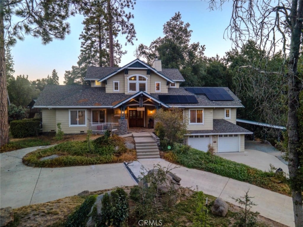 craftsman house with covered porch, solar panels, and a garage