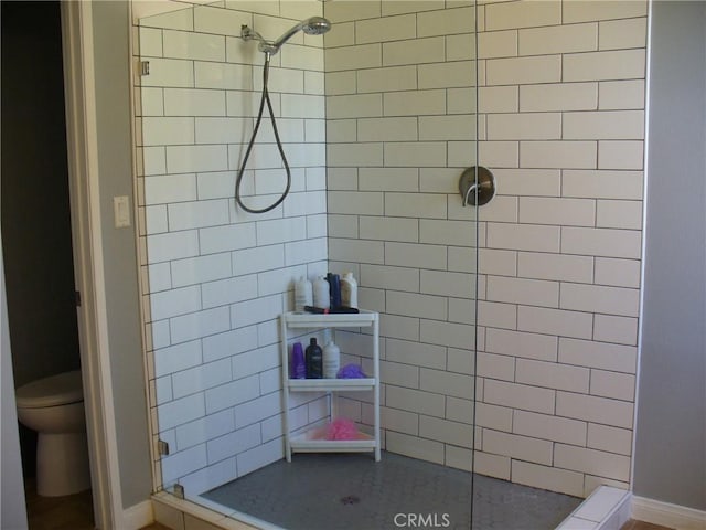 bathroom featuring toilet and tiled shower