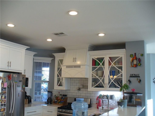 kitchen featuring appliances with stainless steel finishes, decorative backsplash, and white cabinetry