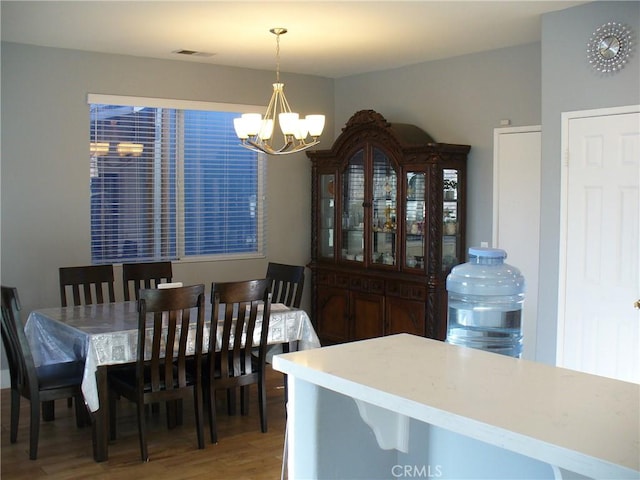 dining space with wood-type flooring and a notable chandelier