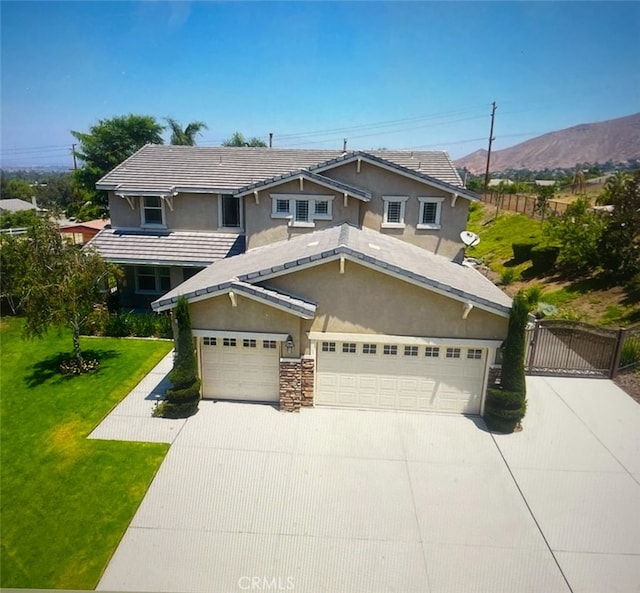 view of front of property featuring a mountain view, a front yard, and a garage