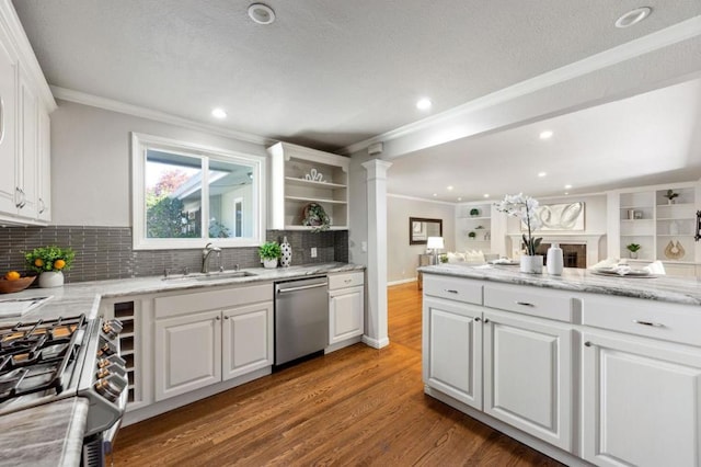 kitchen with sink, hardwood / wood-style flooring, appliances with stainless steel finishes, tasteful backsplash, and white cabinetry