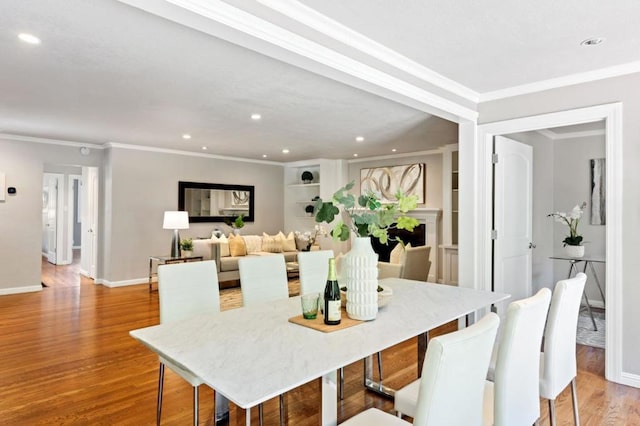 dining area with light hardwood / wood-style floors and crown molding