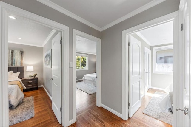 hall with wood-type flooring and ornamental molding