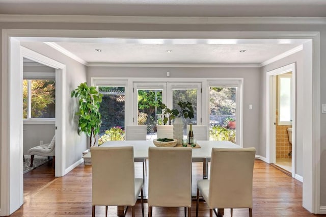 dining room featuring plenty of natural light, light hardwood / wood-style floors, and ornamental molding