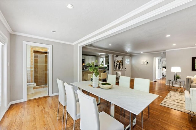 dining space featuring crown molding and light hardwood / wood-style flooring