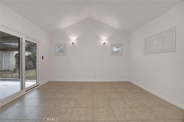 tiled spare room featuring vaulted ceiling