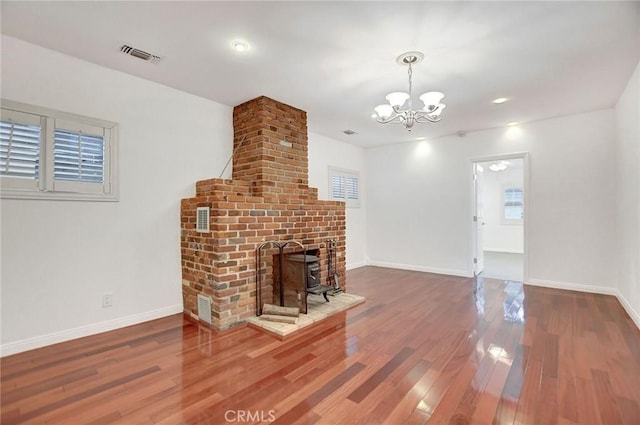 unfurnished living room featuring wood-type flooring and an inviting chandelier