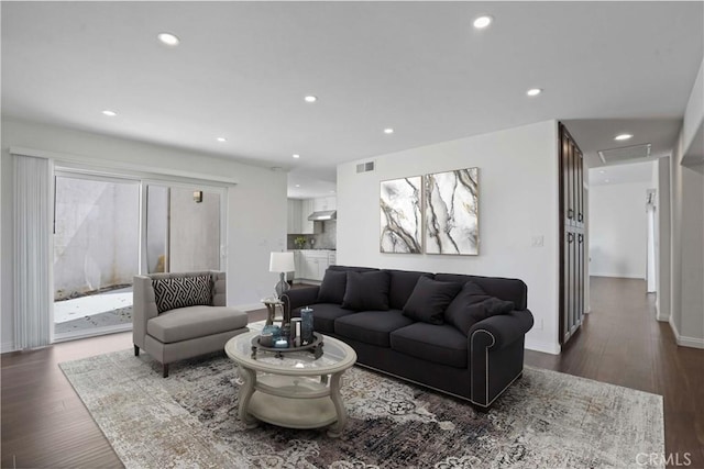 living room with a wealth of natural light and dark wood-type flooring