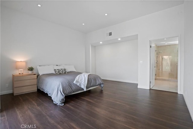 bedroom with connected bathroom and dark hardwood / wood-style flooring