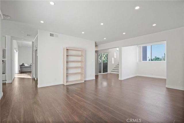 unfurnished living room with a healthy amount of sunlight and dark hardwood / wood-style floors