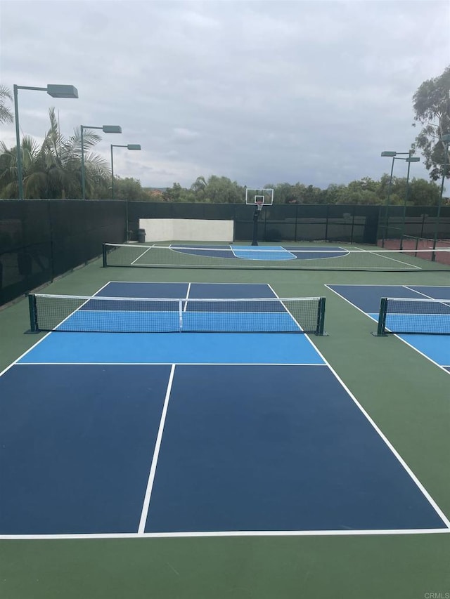 view of tennis court with basketball hoop