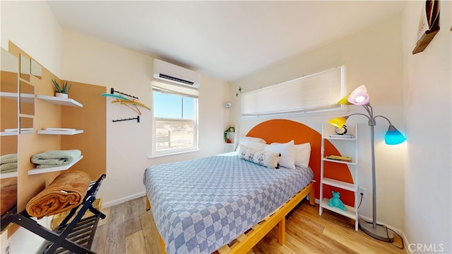 bedroom featuring light hardwood / wood-style flooring and an AC wall unit