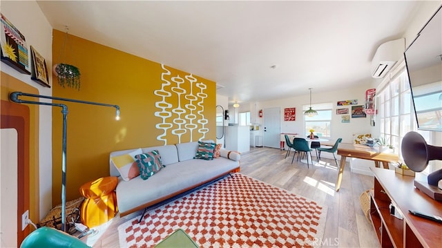 living room featuring light hardwood / wood-style flooring and a wall unit AC