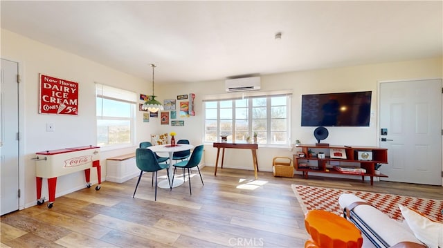 playroom featuring light hardwood / wood-style flooring, an inviting chandelier, a wealth of natural light, and a wall unit AC