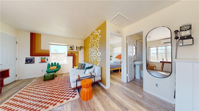 sitting room featuring light hardwood / wood-style flooring and an AC wall unit