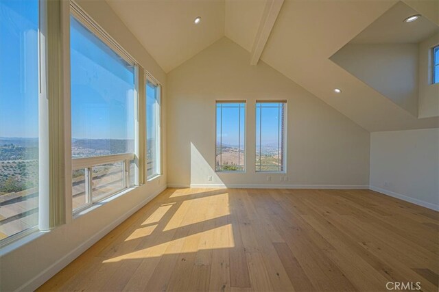 additional living space with vaulted ceiling with beams and light wood-type flooring