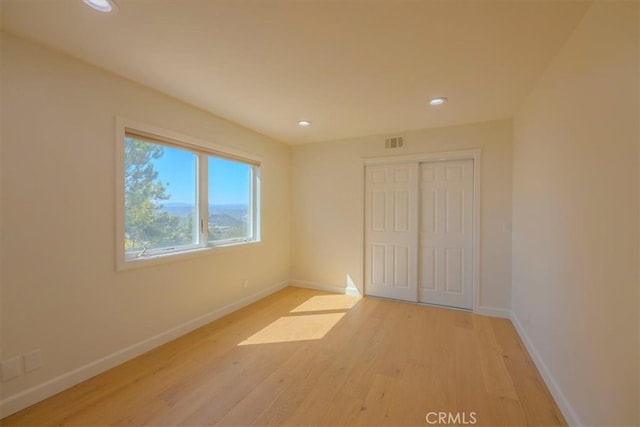 unfurnished bedroom featuring a closet and light wood-type flooring