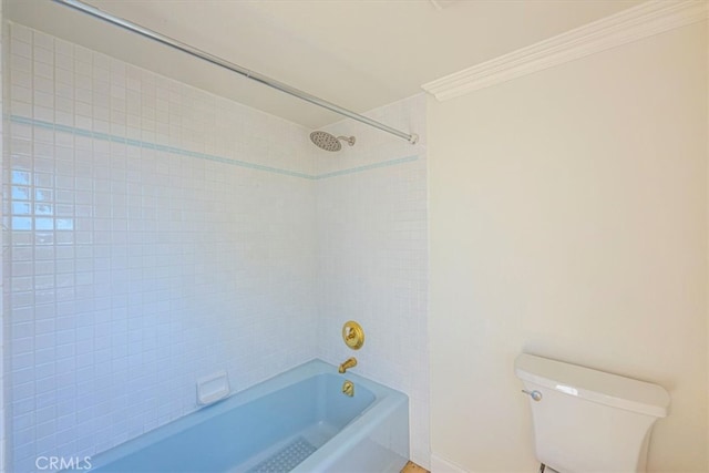 bathroom featuring toilet, crown molding, and tiled shower / bath combo