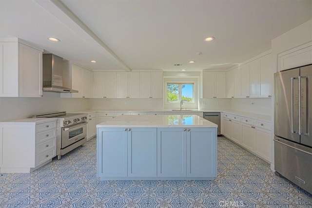 kitchen with white cabinetry, wall chimney exhaust hood, appliances with stainless steel finishes, and a kitchen island