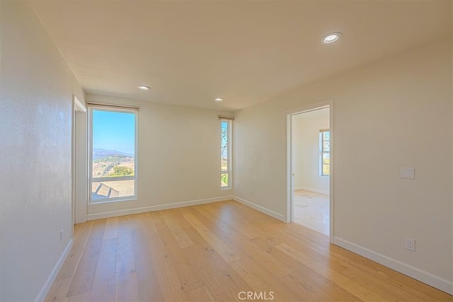 spare room with light wood-type flooring and a wealth of natural light