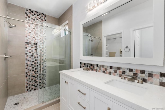 bathroom featuring vanity, backsplash, and walk in shower