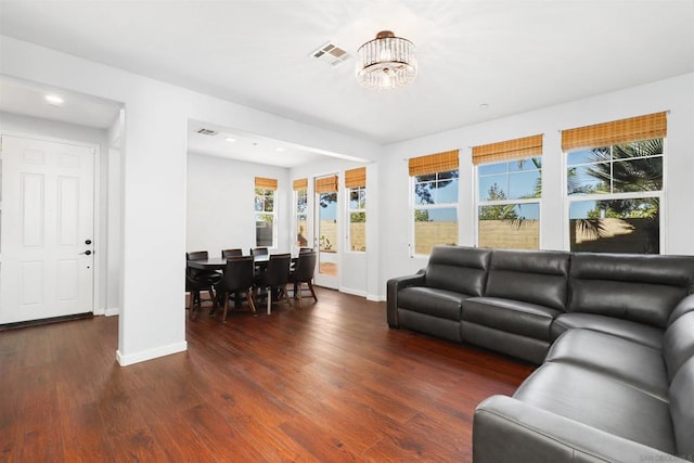 living room featuring dark hardwood / wood-style floors and an inviting chandelier