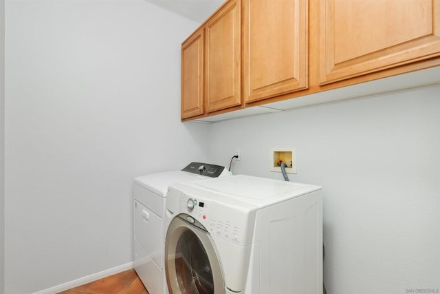 laundry area with washer and dryer and cabinets