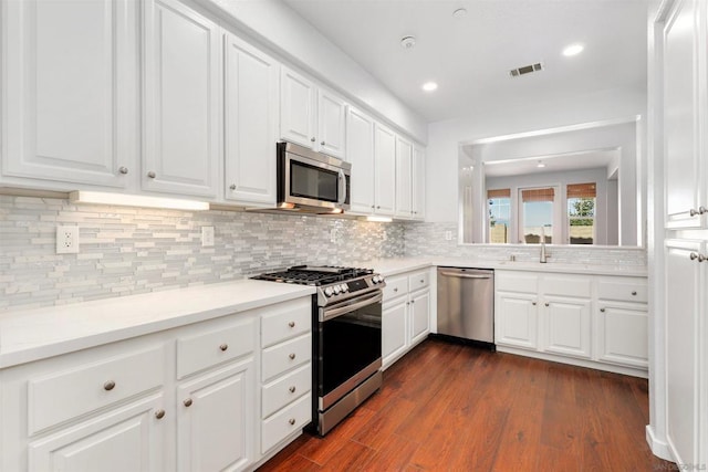 kitchen with white cabinetry, dark wood-type flooring, and stainless steel appliances