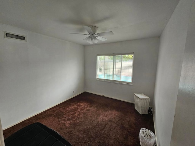 unfurnished room featuring ceiling fan and dark colored carpet