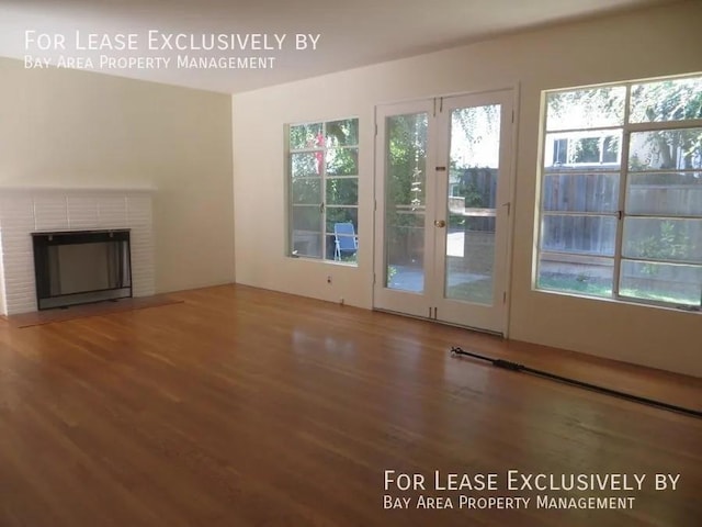 doorway to outside with a brick fireplace and hardwood / wood-style floors