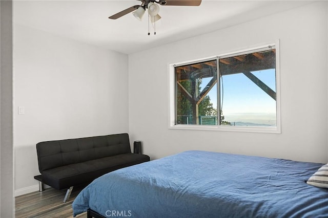 bedroom with baseboards, a ceiling fan, and wood finished floors