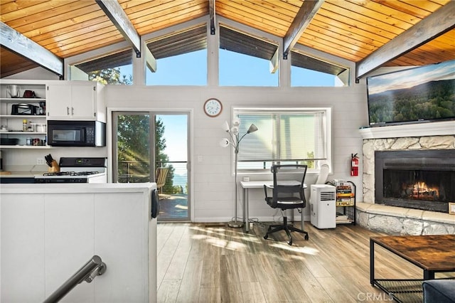 interior space featuring light wood-type flooring, white range with gas cooktop, lofted ceiling with beams, black microwave, and open shelves