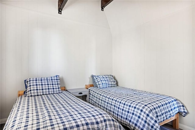 bedroom with vaulted ceiling with beams and wooden walls