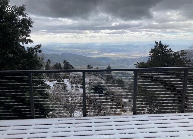 snow covered gate featuring a mountain view