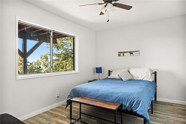 bedroom with wood finished floors, baseboards, and a ceiling fan